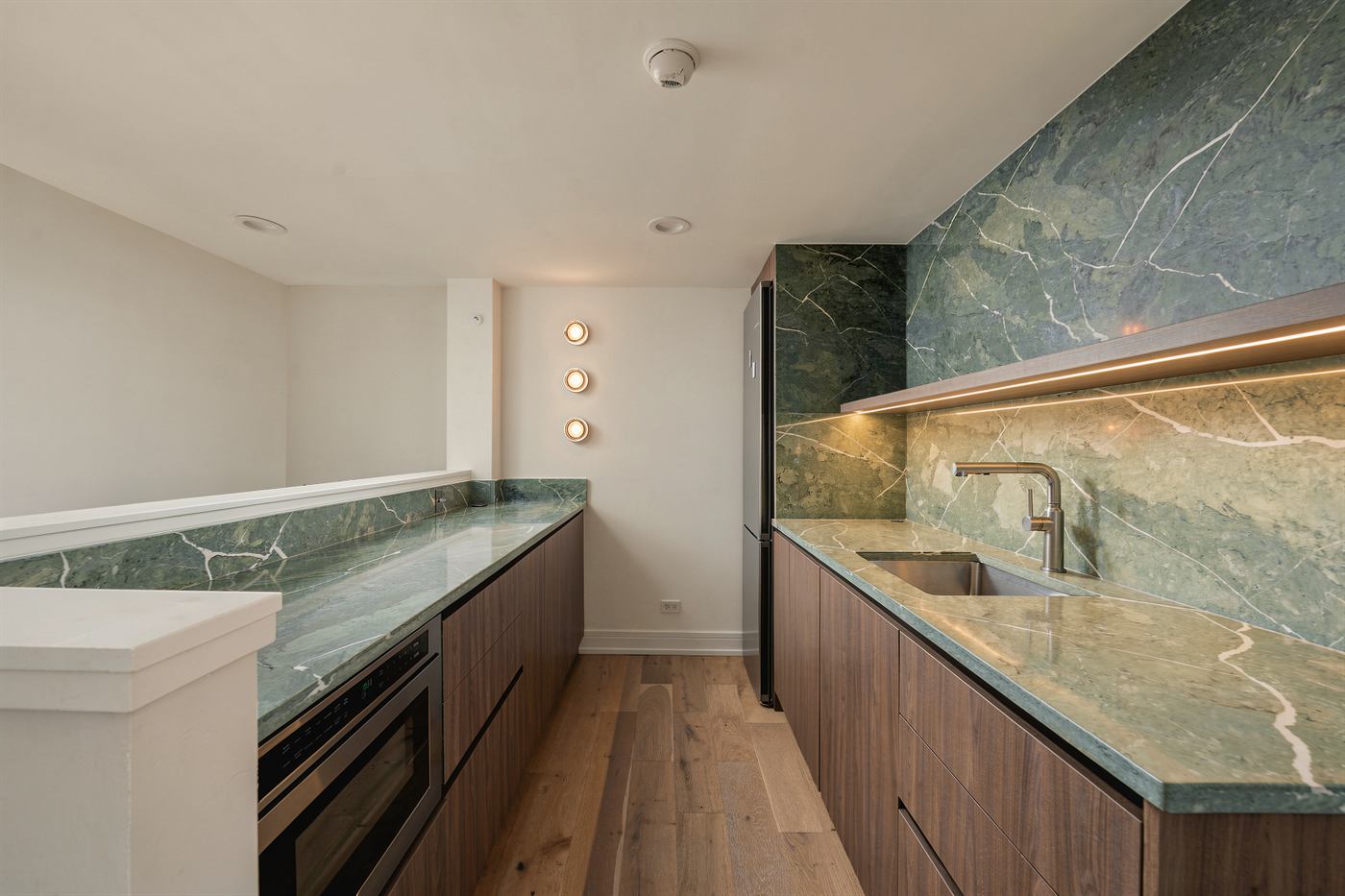 Walnut wet bar run with green marble counter and white oak flooring