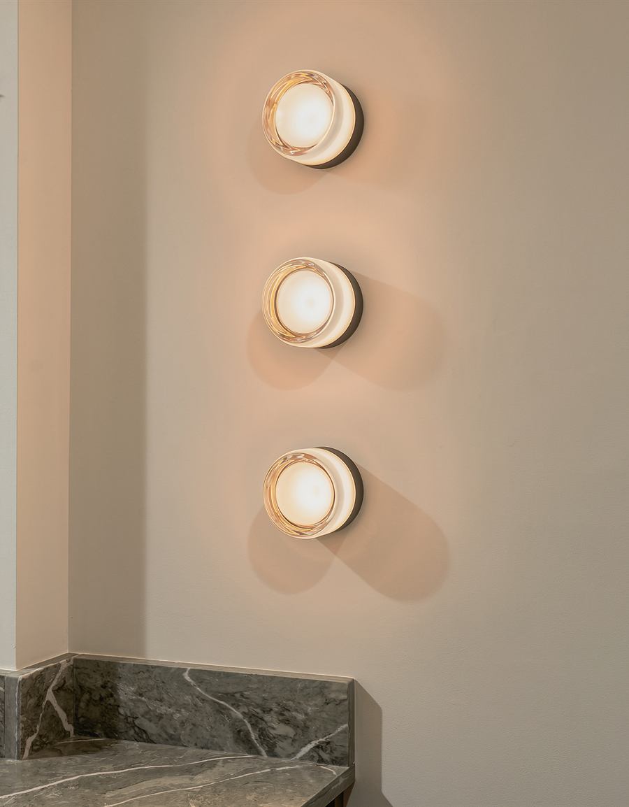 Three wall sconces above a green marble return