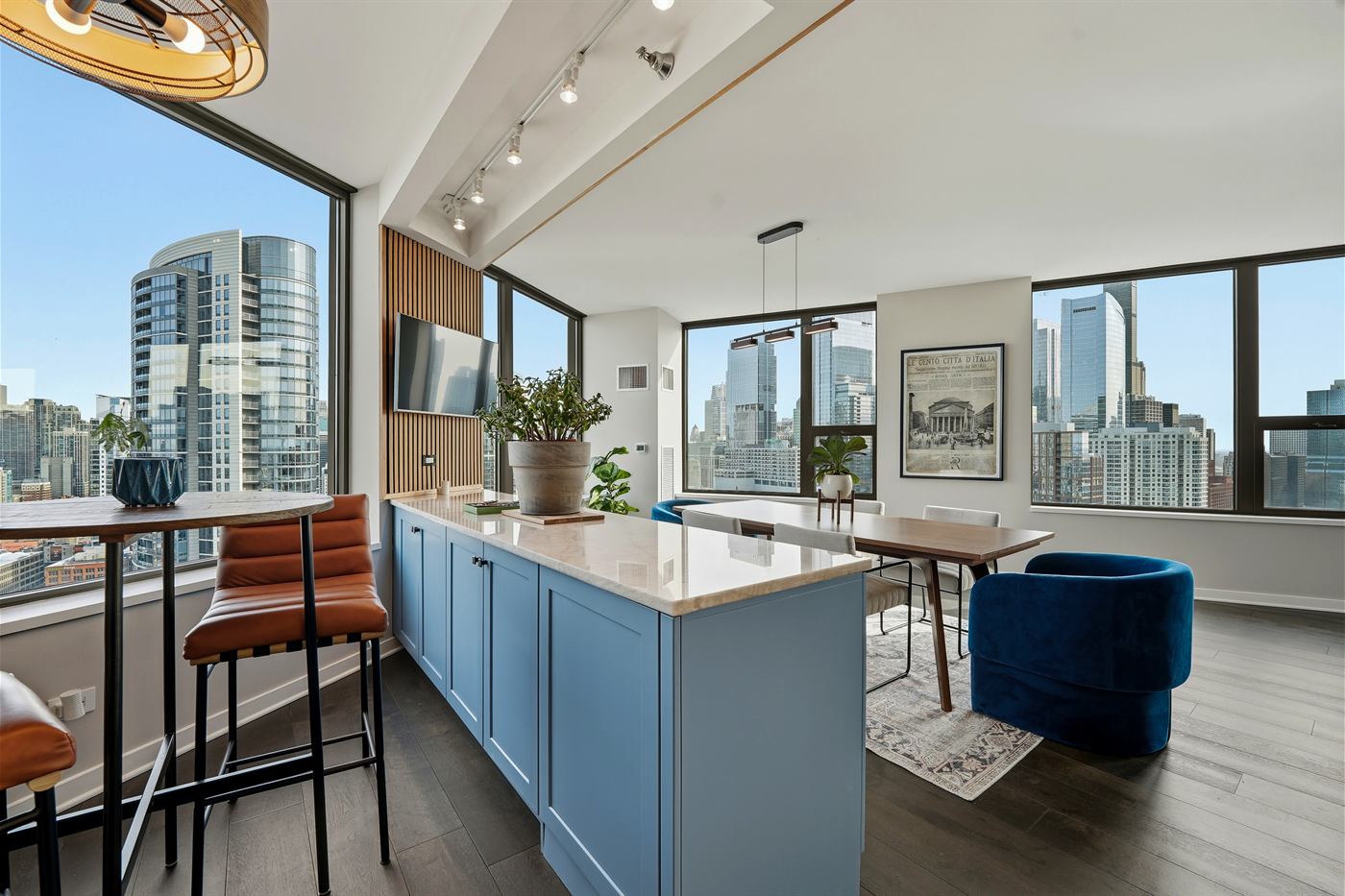 Open kitchen with painted island, stone countertop and floor-to-ceiling skyline windows