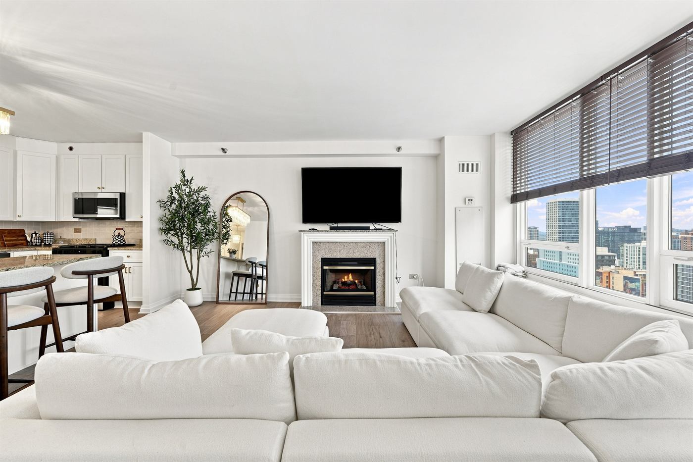 Renovated living room with sectional, fireplace and city windows at 33 W Ontario