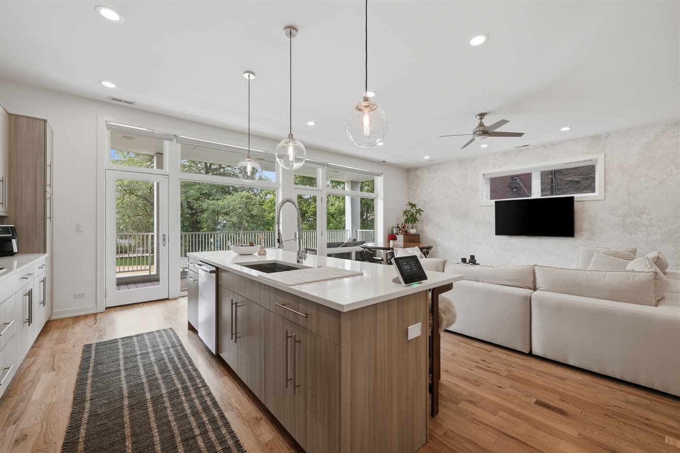 Kitchen island with pendant lighting looking through to the living area