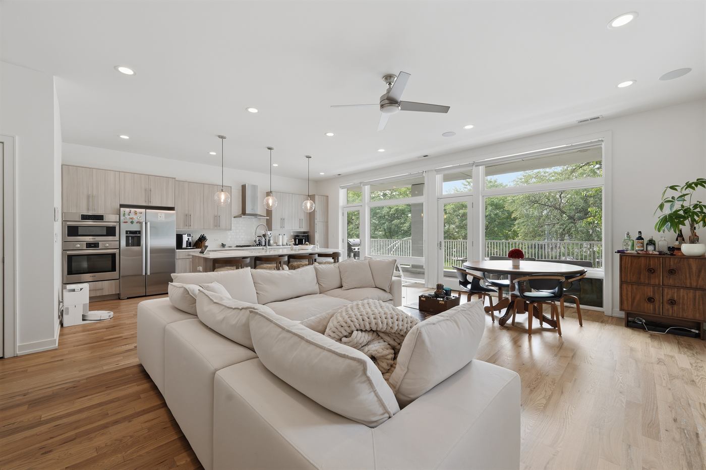 Open-plan living and dining space with white oak floors and full-width rear windows